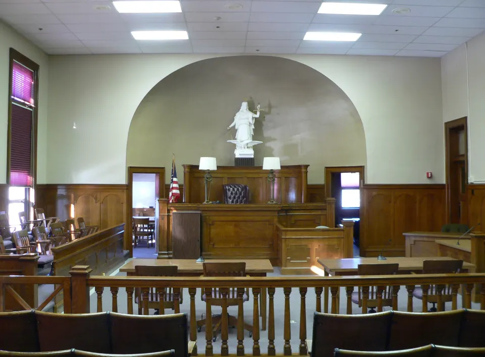 Courtroom with a raised judge's bench and a statue in an arched alcove
