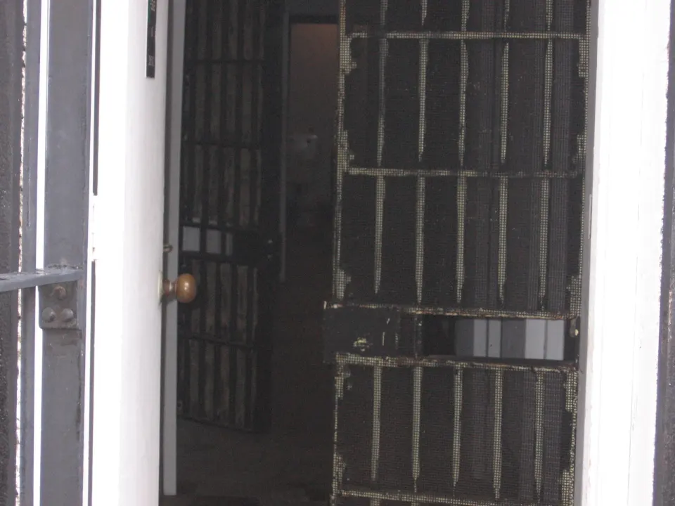 Steel-barred jail cell door in a holding area
