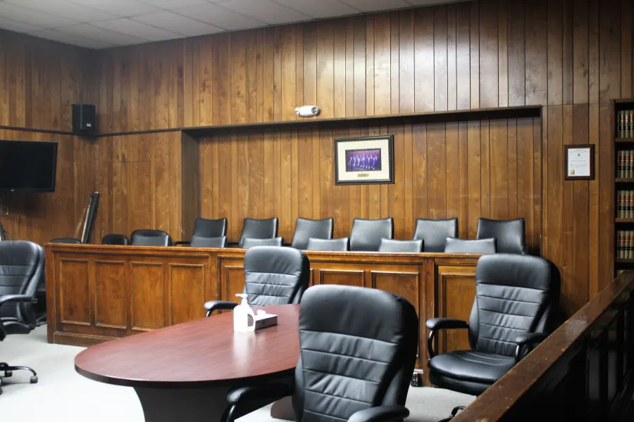 Empty jury box and leather chairs in a courtroom