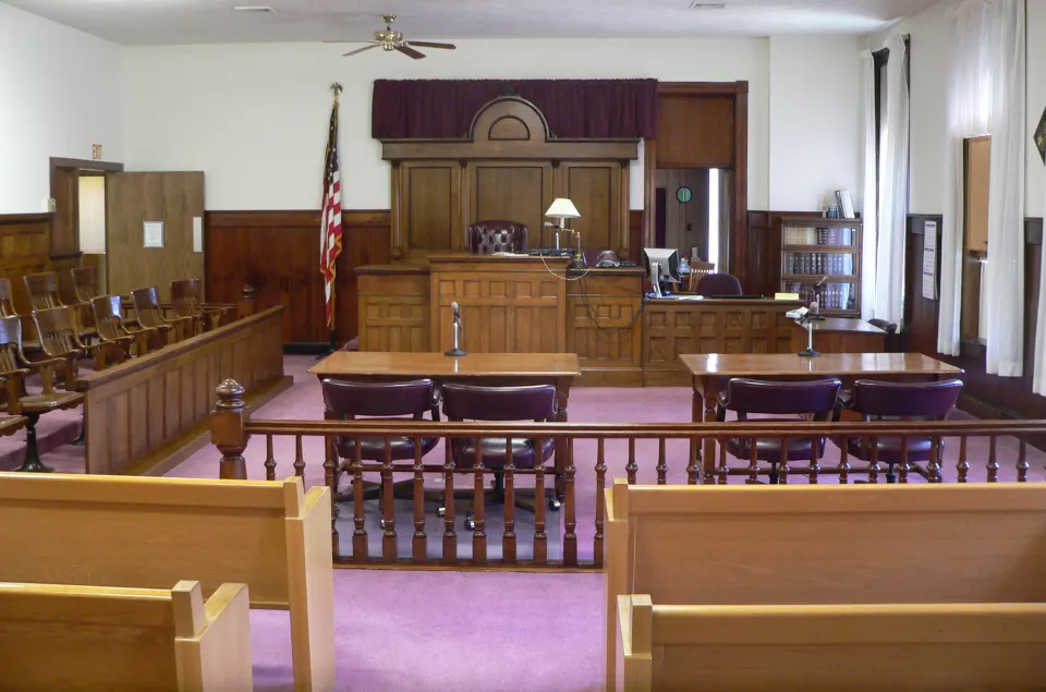 Courtroom with a wooden railing between the gallery and the bench