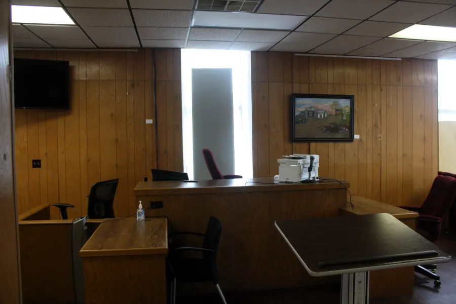 Wood-paneled courtroom with the clerk's desk